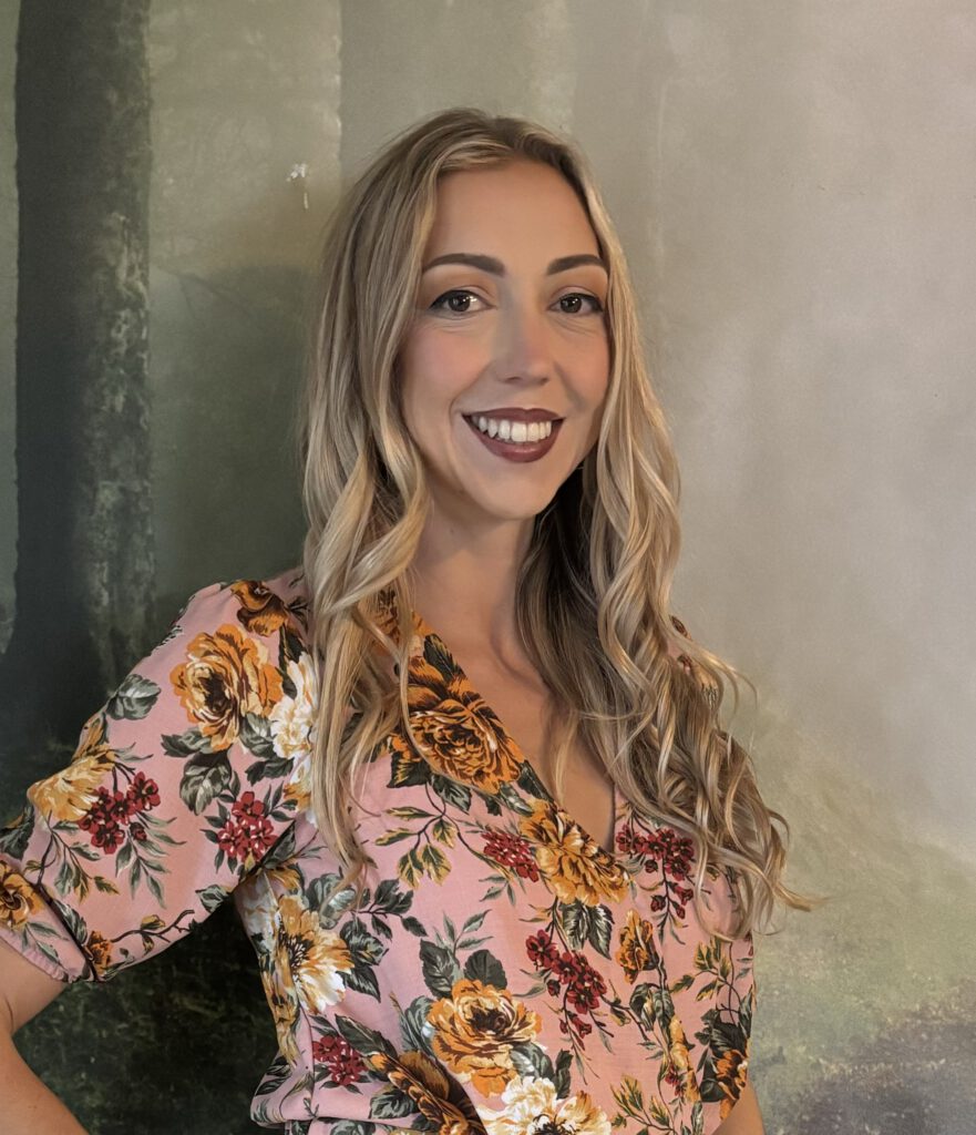 smiling woman with blonde hair in a floral shirt